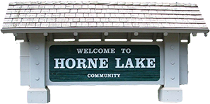 Horne Lake Community logo with large sign in dark green-blue and roof covering and columns in white